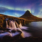 water falls near brown mountain under blue sky during daytime